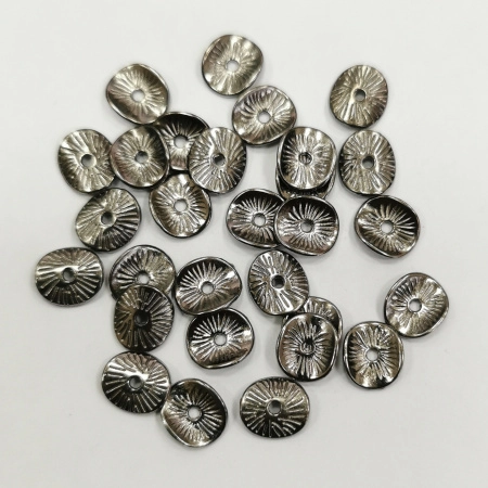 <p>
 Бусина в форме слегка изогнутого диска с насечками. Напоминает тыльную сторону грибной шляпки. Изготовлена из бижутерного сплава с покрытием чёрного цвета. Размер отверстия около 1.1 мм. Толщина металла - около 1 мм. Оттенок может отличаться от фотографии и в разных поставках. На покрытии возможны пятнышки. Цена за 10 грамм (около 24 штук, фасуются без проверки на дефекты).
</p>