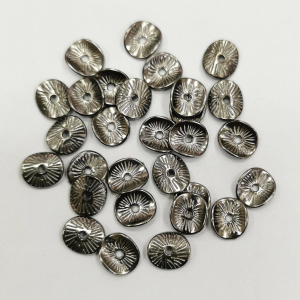 <p>
 Бусина в форме слегка изогнутого диска с насечками. Напоминает тыльную сторону грибной шляпки. Изготовлена из бижутерного сплава с покрытием чёрного цвета. Размер отверстия около 1.1 мм. Толщина металла - около 1 мм. Оттенок может отличаться от фотографии и в разных поставках. На покрытии возможны пятнышки. Цена за 10 грамм (около 24 штук, фасуются без проверки на дефекты).
</p>