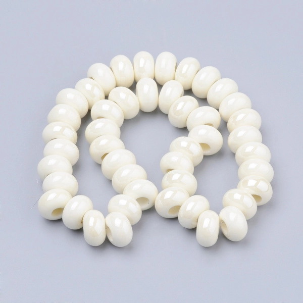 <p>Эффектная бусина из фарфора (porcelain) в форме рондели с крупным отверстием, покрытая глазурью. Бусина сделана вручную. Цвет белый с жемчужным отливом. Оттенок может отличаться от фотографии и в разных поставках (варьируется от белоснежного до айвори). Бусины могут немного отличаться по форме и размеру. Вокруг отверстия могут быть неровности и небольшие сколы. Размер отверстия примерно 5 мм. Цена за 5 бусин.</p>