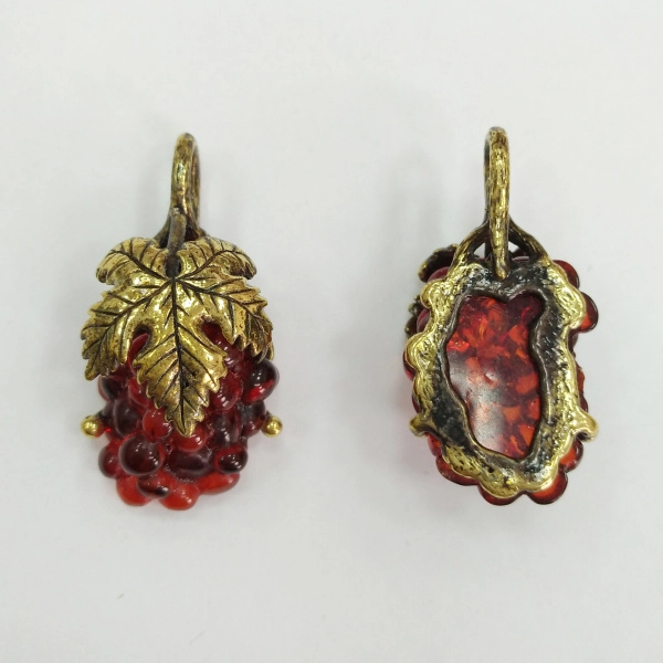 <p>Подвеска - виноградная гроздь. Металлическая часть сделана из бижутерного сплава с покрытием золотистого цвета с чернением. Вставка (виноград) выполнена из прессованного янтаря. Листик может располагаться как по центру грозди, так и со смещением. Оттенок может отличаться от фотографии. По краю возможны небольшие сколы. Цена за 1 шт.</p>