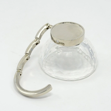 <p>Компактный складной крючок - держатель для сумки. Легко раскладывается, имеет противоскользящую основу, надежно удерживающую крючок на столе или любой другой горизонтальной поверхности. На держателе имеется платформа-рамка для декорирования. Цена за 1 шт.</p>