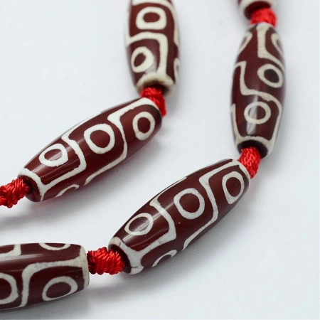 <p>Гладкие вытянутые бусины из натурального камня - тонированного агата, бусина Дзи Девятиглазая. Оттенок может отличаться от фотографии. Бусины могут немного отличаться по форме и размеру. В низке 5 бусин. Низки формируются производителем без проверки каждой бусины на дефекты и подбора по цвету и рисунку. Цена за низку.</p>