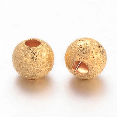 <p>Металлическая бусина с покрытием звездная пыль (stardust) золотистого цвета. Оттенок может отличаться от фотографии. Основной материал из которого изготовлена бусина - латунь. Диаметр отверстия около 1 мм. Цена за 5 грамм (около 54 бусин).</p>