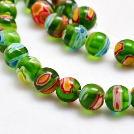 <p>Стеклянные бусины ручной работы, выполнены в технике миллефиори. Зелёные бусинки с разноцветными узорами. Оттенок может отличаться от фотографии и в разных поставках. Цена за низку около 65 бусин (низки формируются без проверки каждой бусины на дефекты).</p>