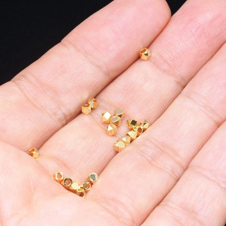 <p>Качественная корейская фурнитура класса люкс. Маленькая металлическая гранёная бусина (многогранник). Диаметр отверстия - около 1.5 мм. Материал латунь, покрытие золото 16 карат. Оттенок может отличаться от фотографии и в разных поставках. На поверхности возможны небольшие неровности. Производство: Южная Корея. Цена за 10 бусин.</p>