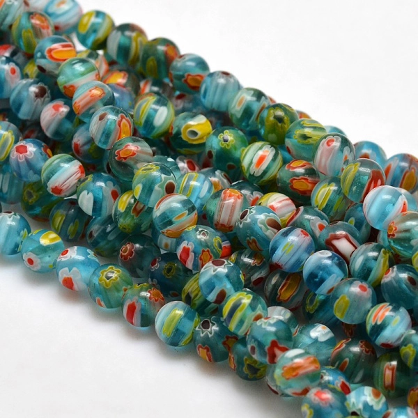 <p>Низка стеклянных бусин ручной работы, выполненных в технике миллефиори. Голубые бусины с разноцветными цветочками. Оттенок может отличаться от фотографии. Цена за низку (около 60 бусин, низки формируются без проверки каждой бусины на дефекты).</p>