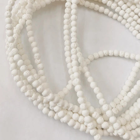 <p>Бусины из измельчённой и спрессованной вулканической лавы (вулканического туфа), тонированной в белый цвет. На бусинах может быть виден шов, возможны неровности на поверхности. Оттенок может отличаться от фотографии и в разных поставках. Диаметр отверстия около 1 мм. Могут немного отличаться по форме и размеру. Бусины покрыты белой пылью от сверления, рекомендуется их протереть или промыть их перед использованием. Цена за низку, около 96 бусин. Низки формируются без проверки каждой бусины на дефекты.</p>