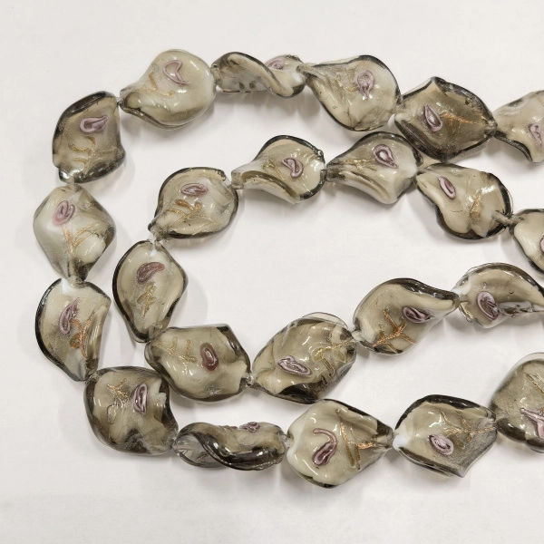 <p>Эффектная витая бусина - стеклянный листик ручной работы. Выполнена из стекла в технике лэмпворк (lampwork). На бусине изображена стилизованная розочка (круглая спираль с золотисто-медным узором). Бусины могут отличаться по форме и размеру. Оттенок может отличаться от фотографии. Цена за 5 шт.</p>