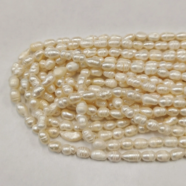 <p>Бусины из культивированного пресноводного жемчуга неправильной вытянутой формы. Бусины могут отличаться по форме и размеру, оттенок может отличаться от фотографии. На бусинах возможны потертости, неровности, царапинки. Цена за низку длиной примерно 34 см (около 35-45 жемчужин, в зависимости от размера бусин; низки формируются без проверки каждой бусины на дефекты).</p>