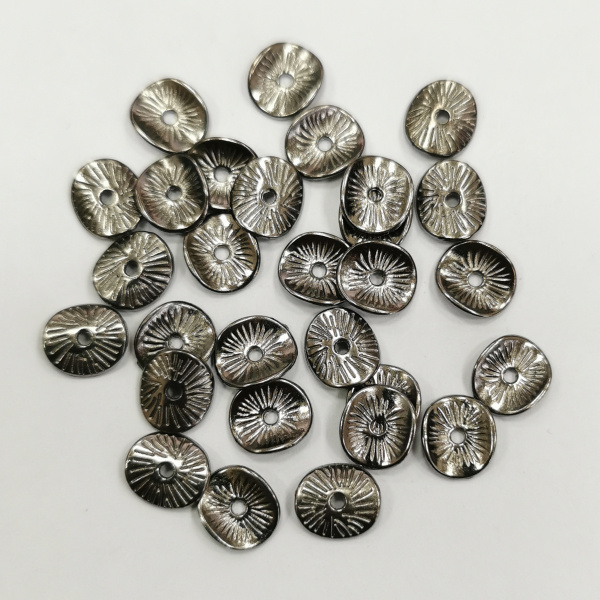 <p>
 Бусина в форме слегка изогнутого диска с насечками. Напоминает тыльную сторону грибной шляпки. Изготовлена из бижутерного сплава с покрытием чёрного цвета. Размер отверстия около 1.1 мм. Толщина металла - около 1 мм. Оттенок может отличаться от фотографии и в разных поставках. На покрытии возможны пятнышки. Цена за 10 грамм (около 24 штук, фасуются без проверки на дефекты).
</p>