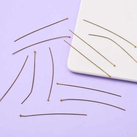 <p>Бюджетные длинные пины с шариком бронзового цвета. Длина около 7 см, диаметр пина около 0,7 мм, диаметр шарика около 1,5-2,5 мм. Головка на пине может быть расположена не точно по центру, пины могут быть погнуты. Оттенок может отличаться от фотографии и в разных поставках. Цена за 10 грамм (около 43 штук, фасуются без проверки на дефекты).</p>