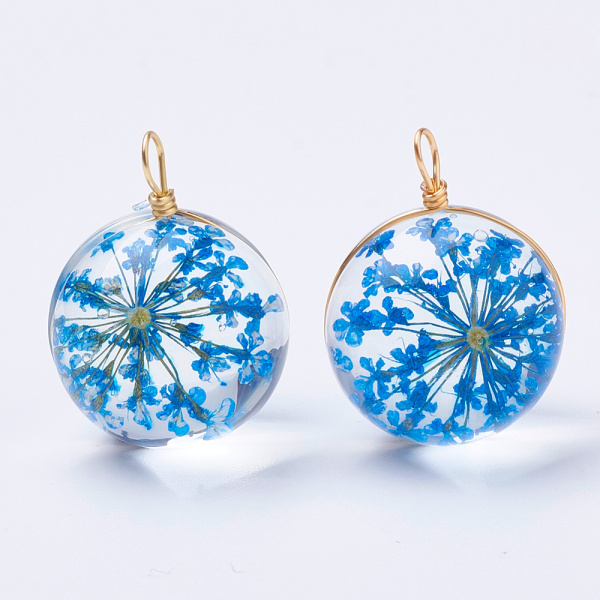 <p>Круглая стеклянная подвеска с сухоцветом внутри. Подвеска представляет собой две склеенных стеклянных полусферы с засушенным цветком между ними, сверху сделана петелька для подвешивания из проволоки золотистого цвета. Отлично будет смотреться как кулон, серьги или брелок. Оттенок может отличаться от фотографии и в разных поставках. Цена за 1 подвеску.</p>