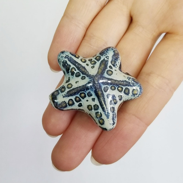 <p>Крупная эффектная керамическая бусина - морская звездочка ручной работы. Бусина покрыта глазурью светло-бежевого цвета с сине-голубыми и коричневыми узорами. Цвет может отличаться от фотографии. Бусины могут отличаться по форме и размеру, рисунок на каждой бусине уникален. Диаметр отверстия - около 2.5 мм. Цена за 1 бусину.</p><p>ВНИМАНИЕ: отверстие сделано не очень аккуратно, возможны небольшие сколы у отверстия.</p>