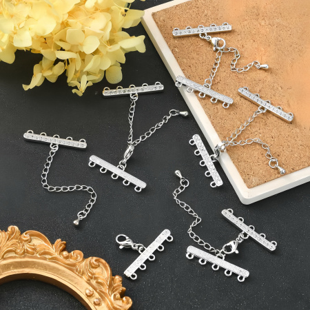 <p>Элитная ювелирная фурнитура премиум класса - Милано люкс (Milano Lux), качественный элемент для создания бижутерии. Набор для окончания многорядного украшения или широкого плетёного браслета/колье. В набор входят 2 соединителя-переходника с 5 на 1 нить размером 28*8 мм, инкрустированных кристально-прозрачными стразами - фианитами (Cubic Zirconia – кубик циркония, CZ, цирконы). К одному концевику прикреплена застежка карабин (лобстер), к другому - цепочка-удлинитель длиной около 5 см. и декоративной капелькой на конце. В застёгнутом виде длина концевиком вместе с замочком (без учёта удлинителя) составляет около 28 мм. Цвет под родий. Оттенок может отличаться от фотографии и в разных поставках. При желании концевики можно отсоединить и использовать как коннекторы или подвески. Цена за 1 набор.</p>