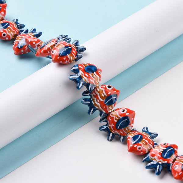 <p>Бусина из фарфора - коралловая рыбка ручной работы. Напоминает тропическую рыбу - бабочку. Бусины слеплены и расписаны вручную: могут отличаться по форме, рисунку и размеру. Размер отверстия около 1-2 мм. Оттенок может отличаться от фотографии и в разных поставках. Цена за 1 бусину.</p>