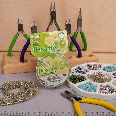 <p>Профессиональный ювелирный тросик Flex-Rite с нейлоновым покрытием. 49-жильный тросик премиум-класса. Цвет золотой, матовый. Оттенок может немного отличаться от фотографии и в разных поставках. Цена за катушку 30 футов (9.1 метра).</p>