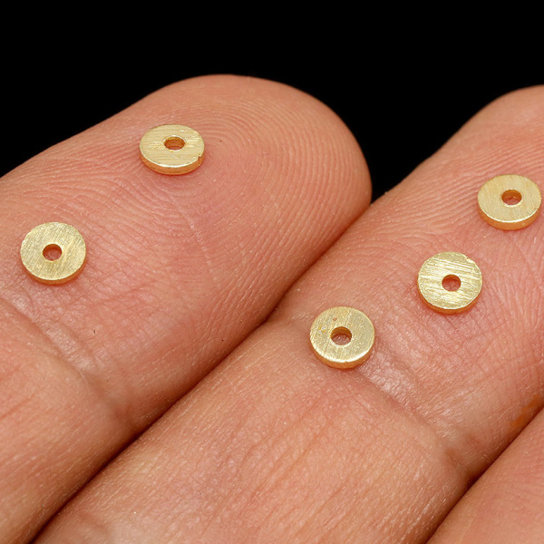 <p>
 Качественная корейская фурнитура класса люкс. Металлическая бусина - узкая рондель Heishi (диск, чипс) с шершавой поверхностью. Диаметр отверстия - около 0.8-0.9мм. Материал - латунь, покрытие - позолота 16 карат. Оттенок может отличаться от фотографии и в разных поставках. Бусины могут немного отличаться по форме и размеру, отверстие может быть не строго по центру. Цена за 10 шт.
</p>