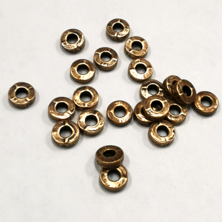 <p>Бусина в форме узкой гладкой рондели. Под медь с небольшим чернением. Оттенок может отличаться от фотографии. Диаметр отверстия с одной стороны около 2.5 мм, с другой около 2.9 мм. Отверстие может быть сделано не точно по центру. Возможны небольшие неровности. Цена за 5 грамм (около 20 бусин, фасуются на вес без проверки на дефекты).</p>