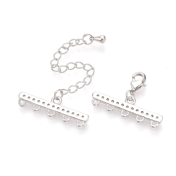 <p>Элитная ювелирная фурнитура премиум класса - Милано люкс (Milano Lux), качественный элемент для создания бижутерии. Набор для окончания многорядного украшения или широкого плетёного браслета/колье. В набор входят 2 соединителя-переходника с 5 на 1 нить размером 28*8 мм, инкрустированных кристально-прозрачными стразами - фианитами (Cubic Zirconia – кубик циркония, CZ, цирконы). К одному концевику прикреплена застежка карабин (лобстер), к другому - цепочка-удлинитель длиной около 5 см. и декоративной капелькой на конце. В застёгнутом виде длина концевиком вместе с замочком (без учёта удлинителя) составляет около 28 мм. Цвет под родий. Оттенок может отличаться от фотографии и в разных поставках. При желании концевики можно отсоединить и использовать как коннекторы или подвески. Цена за 1 набор.</p>