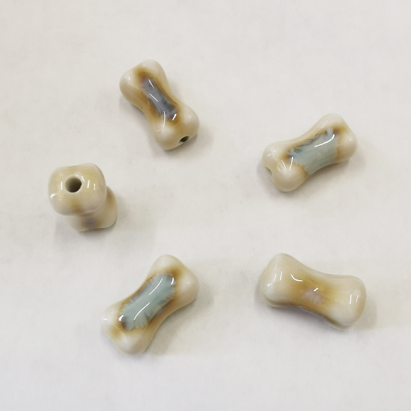 <p>Фарфоровая (порцелановая) бусина - кость ручной работы. Цвет - бежевый с голубовато-серым. Отверстие примерно 2 мм. Оттенок может отличаться от фотографии и в разных поставках. Цена за 5 бусин.</p>