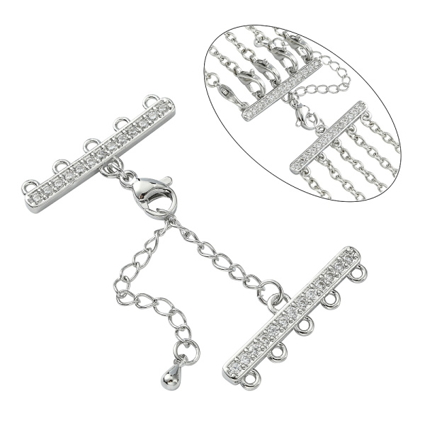 <p>Элитная ювелирная фурнитура премиум класса - Милано люкс (Milano Lux), качественный элемент для создания бижутерии. Набор для окончания многорядного украшения или широкого плетёного браслета/колье. В набор входят 2 соединителя-переходника с 5 на 1 нить размером 28*8 мм, инкрустированных кристально-прозрачными стразами - фианитами (Cubic Zirconia – кубик циркония, CZ, цирконы). К одному концевику прикреплена застежка карабин (лобстер), к другому - цепочка-удлинитель длиной около 5 см. и декоративной капелькой на конце. В застёгнутом виде длина концевиком вместе с замочком (без учёта удлинителя) составляет около 28 мм. Цвет под родий. Оттенок может отличаться от фотографии и в разных поставках. При желании концевики можно отсоединить и использовать как коннекторы или подвески. Цена за 1 набор.</p>